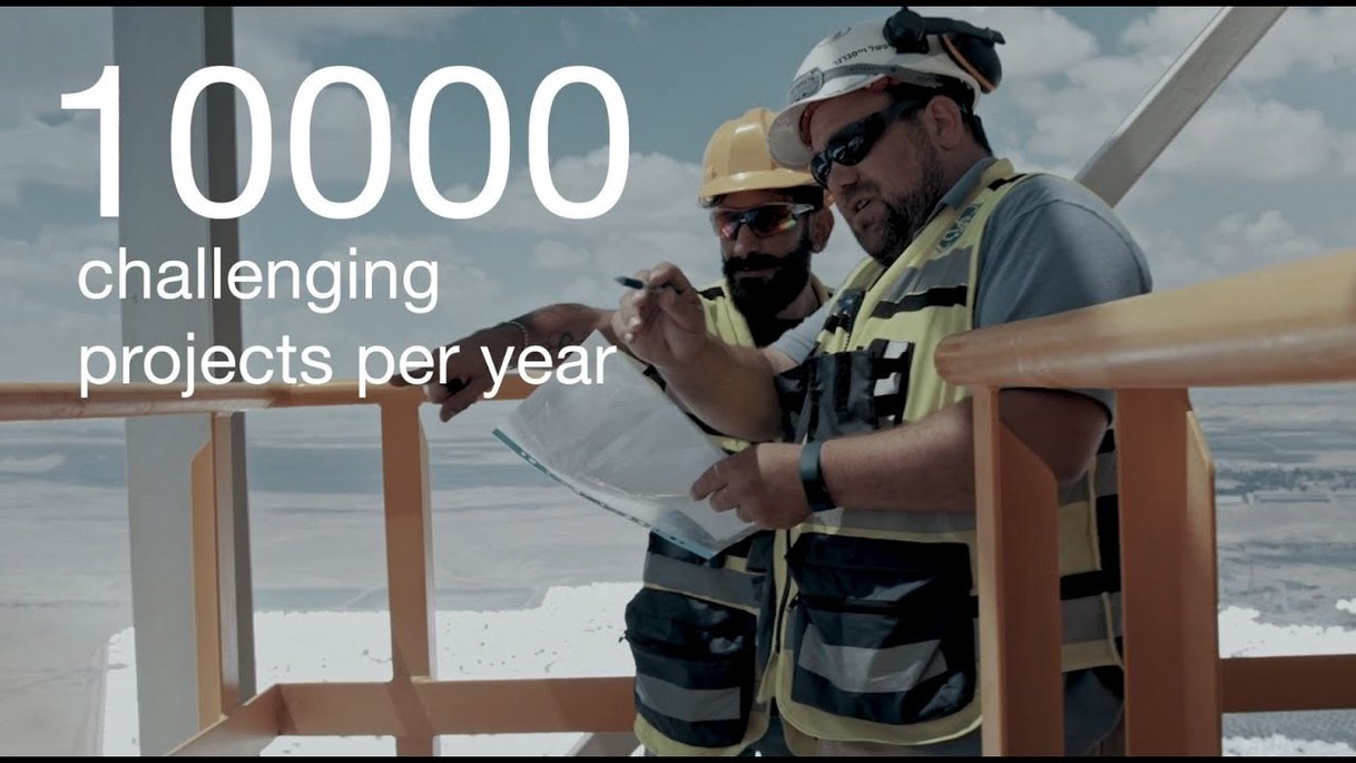 Zwei Arbeiter auf einem Windrad. Schriftzug: 10000 challenging projects per year