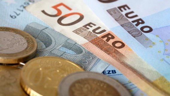 Geld Verschiedene Geldscheine und Münzen der Währung Euro liegen übereinander.