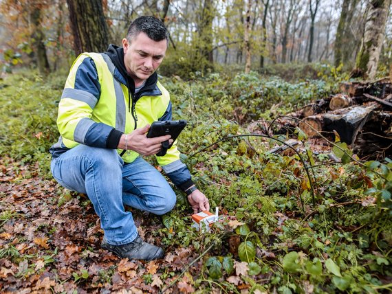 Mitarbeiter der Line Crew legt am Waldrand ein Geophon für eine seismische Messung aus