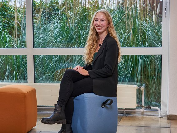 Alisha Gertack Alisha Gertack sitzt auf einem blauen Hocker