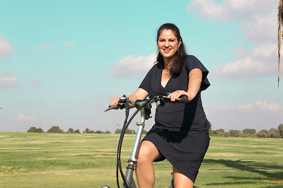 Lara Smith, Managing Director von CORE CONSULTANTS auf ihrem E-Bike in Tel Aviv