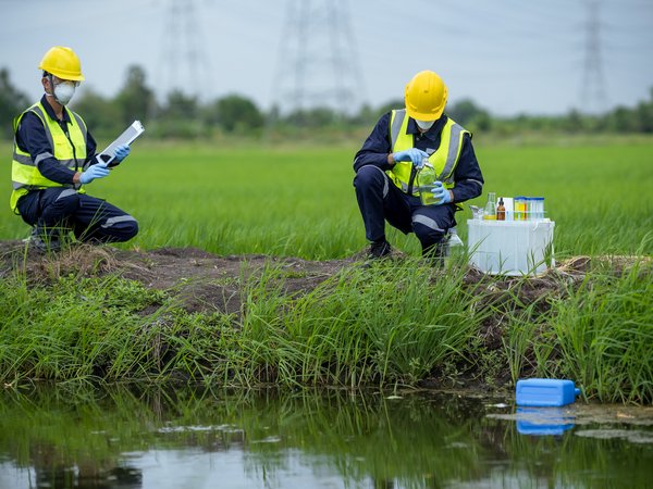 Umweltforscher untersuchen den Zustand des Kanalwassers auf Giftstoffe, nehmen Flussabwässer, asiatische Forscher sammeln Wasserproben in Ackerland für Forschung und Entwicklung.