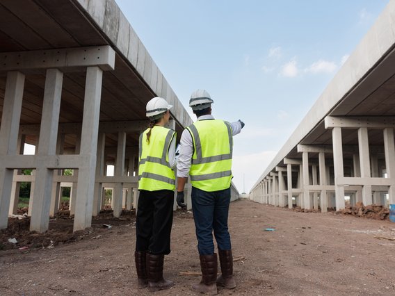 Ein Ingenieur und eine Ingenieurin auf einer Infrastruktur-Baustelle