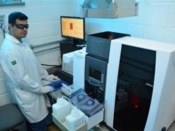 Técnico realizando teste de análise de água Um técnico fica em frente a um dispositivo e realiza análises da água.