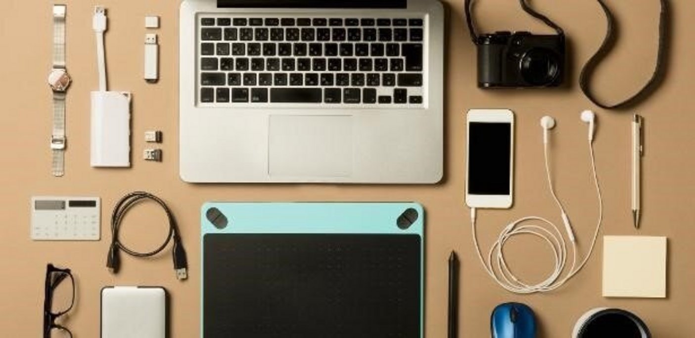 Dispositivos eletrônicos que contém elementos de terras raras em sua composição Dispositivos eletrônicos em uma mesa que contêm terras raras em sua composição: por exemplo, laptop, telefone celular, câmera, relógio, óculos, cabo de carregamento, mouse, tablet