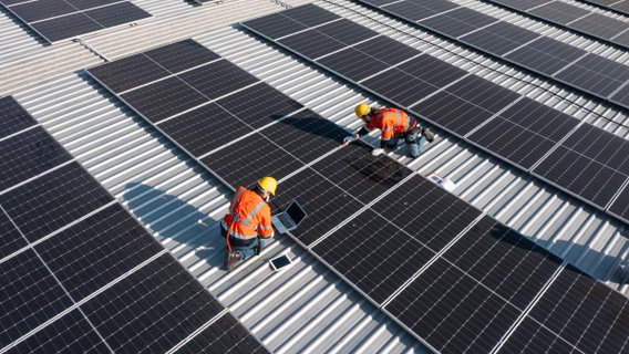 Techniker bei der Installation von Photovoltaikanlagen auf einem Dach