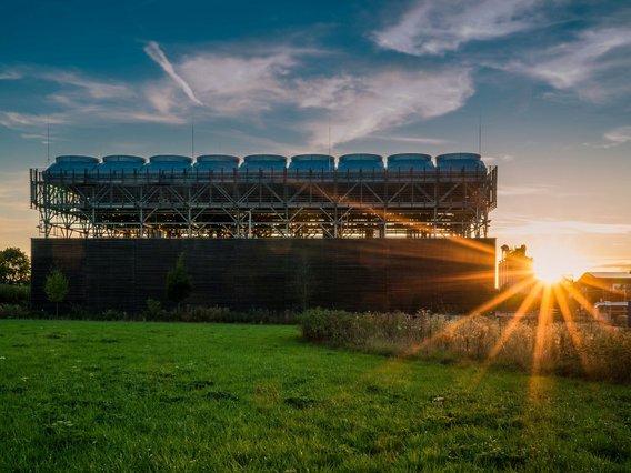 Energieanlage_Geothermie industrielle Anlage, vermutlich ein Kühlturm oder eine Energieanlage, bei Sonnenuntergang.