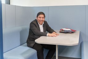 Ray Bolano sitzt in einer Sitzecke