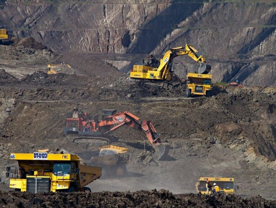 Mineração a céu aberto Mineração a céu aberto - escavadeiras carregam terra e rocha em caminhões