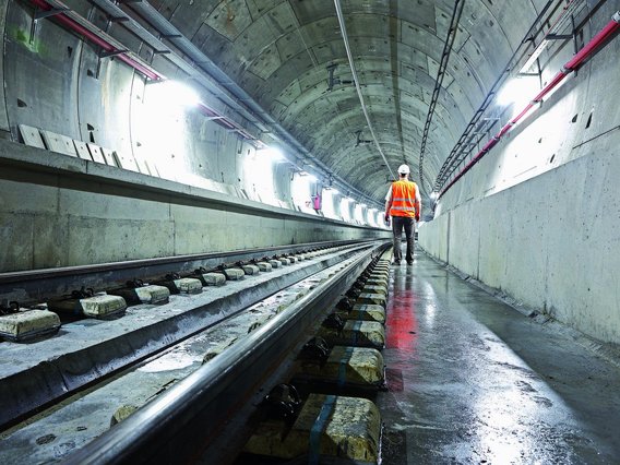 Ein Ingenieur ist von hinten in einem hell erleuchteten Betontunnel zu sehen