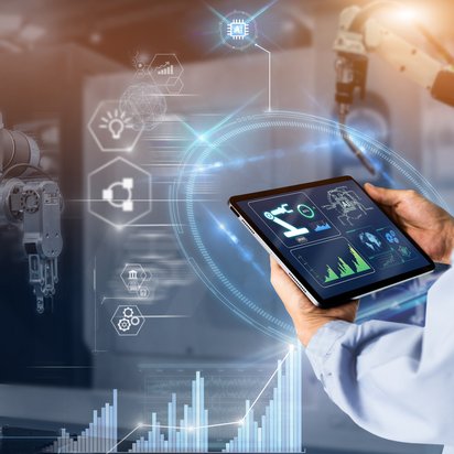 Transparenz in der Produktion Symbolbild zum Thema Transparenz in der Produktion: Ingenieur hält ein Notebook, auf dem Monitoringwerte der überwachten Maschine erscheinen.