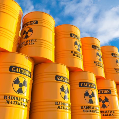 Fässer mit Aufschrift des Radioaktivität-Warnsymbols und der Aufschrift "Caution, radioactive material"