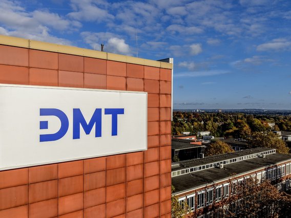 Luftbild eines Gebäudes auf dem DMT-Standort Essen, mit einem großen Schild, das das DMT-Logo zeigt.
