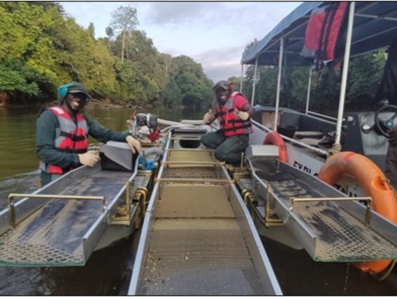 Mineralsand-Projekt in Gabun DMT Kai Batla Mitarbeitende auf einem Boot untersuchen Flusssedimente im Rahmen eines Mineralsand-Projekts in Gabun.