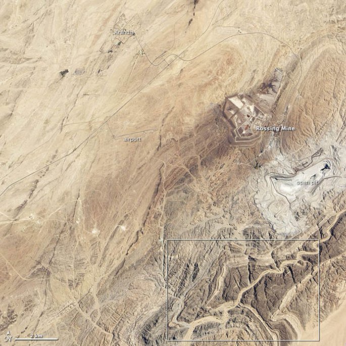 Identificação de alvos de prospecção mineral por análise de imagens aéreas. Uma foto aérea mostra uma área ao redor de uma mina.