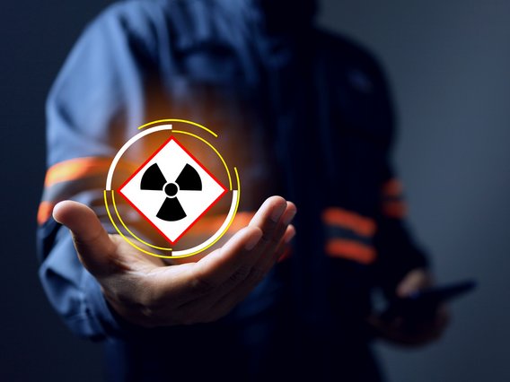 Person hält ein virtuelles Radioaktivitätssymbol auf der Handfläche