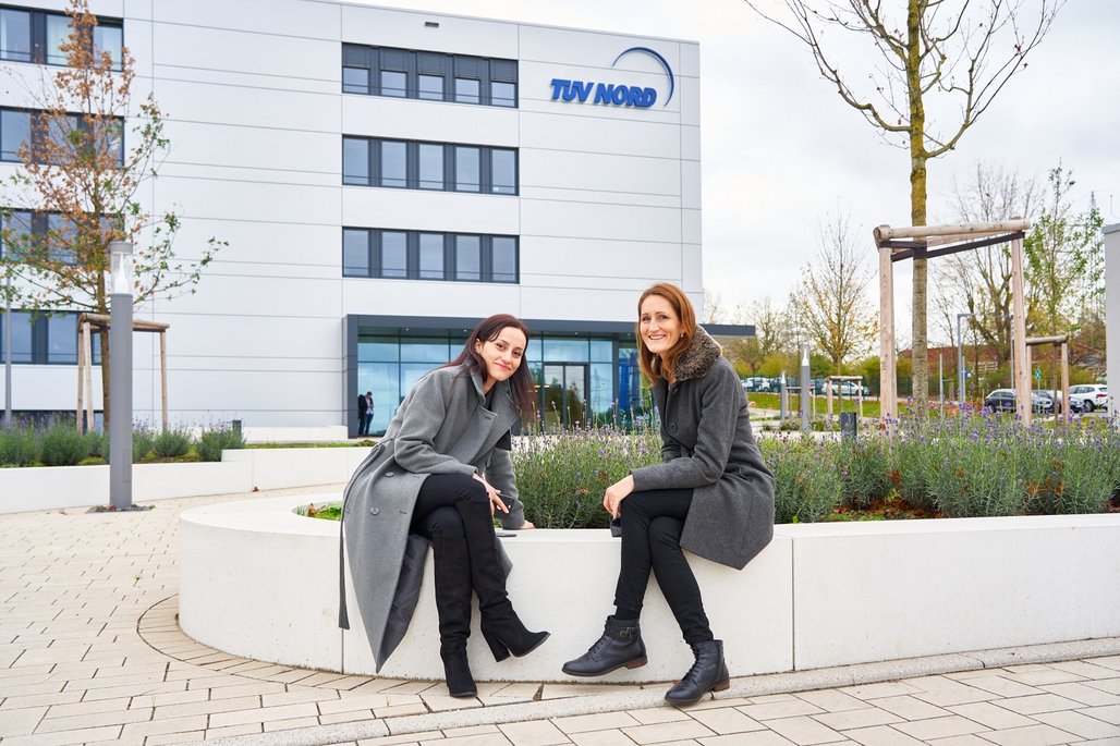 Suzan Bayram Suzan Bayram und Natalie Morris sitzen auf einer Blumenbeetumrandung