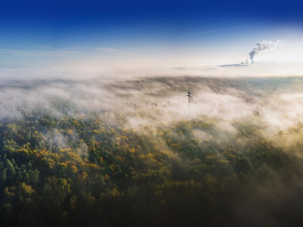 weite Landschaft, die von einem dichten Nebel oder Dunst bedeckt ist.