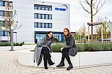 2 Frauen auf einer Bank vor der Zentrale der TÜV NORD GROUP in Essen
