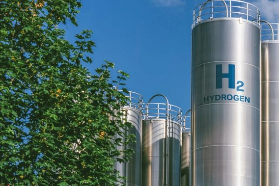 Wasserstoffanlage und -tanks Silberne Silos oder Tanks für Wasserstoff unter klaren, blauen Himmel mit einigen weißen Wolken.