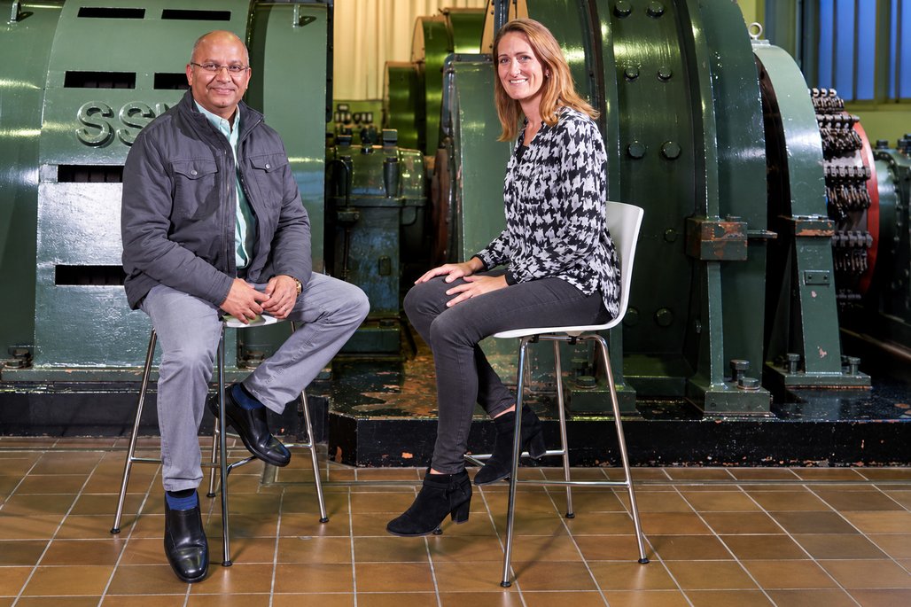 Sanjey Bhoowanpursadh und Natalie Morris sitzen vor einer großen Maschine