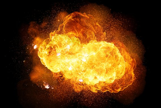 Feurige Explosion mit Funken und Rauch auf schwarzem Hintergrund