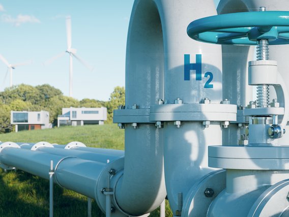 Große, silberne Pipeline mit einem Ventil und einem Druckmesser im Vordergrund. 
