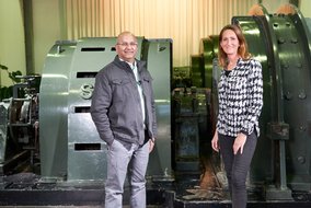 Sanjey Bhoowanpursadh und Natalie Morris stehen vor einer großen Maschine