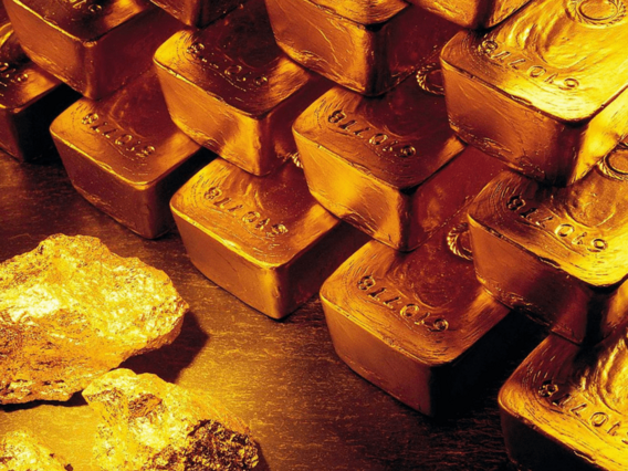Barras de ouro Barras de ouro em uma mesa. Três pedaços de ouro em frente a ela.
