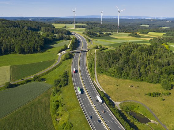 Symbolbild zum Thema Kreuzungs- und Genehmigungsmanagement: Luftbild einer Autobahn, die von einer Landstraßenbrücke überquert wird