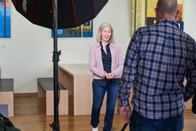 Mary Anderson steht vor einem Tisch mit zwei Bänken