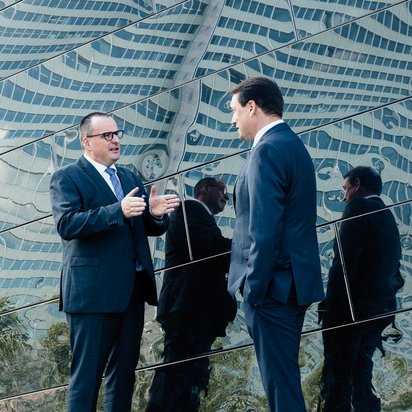 Jens-Peter Lux, DMT GROUP, Geschäftsführer und Dr. Jürgen Franz Jens-Peter Lux, DMT GROUP, Geschäftsführer und Dr. Jürgen Franz unterhalten sich vor einem modernen Gebäude aus Spiegelglas.