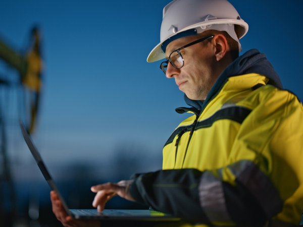 Ingenieur mit Laptop bei der Arbeit in der Abenddämmerung