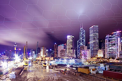 Beleuchtete Baustelle vor einer modernen Großstadt-Skyline | DMT Group Beleuchtete Baustelle vor einer modernen Großstadt-Skyline | DMT Group