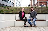 Was für uns spricht, sind unsere Mitarbeitenden Ein Kollege und eine Kollegin sitzen draußen auf einer Bank