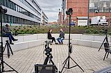 What speaks for us are our employees 2 people surrounded by camera equipment